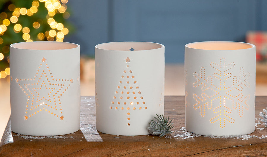 Winterliches Windlicht-Set aus Porzellan mit leuchtenden Motiven – dekorativ arrangiert zur Weihnachtszeit
