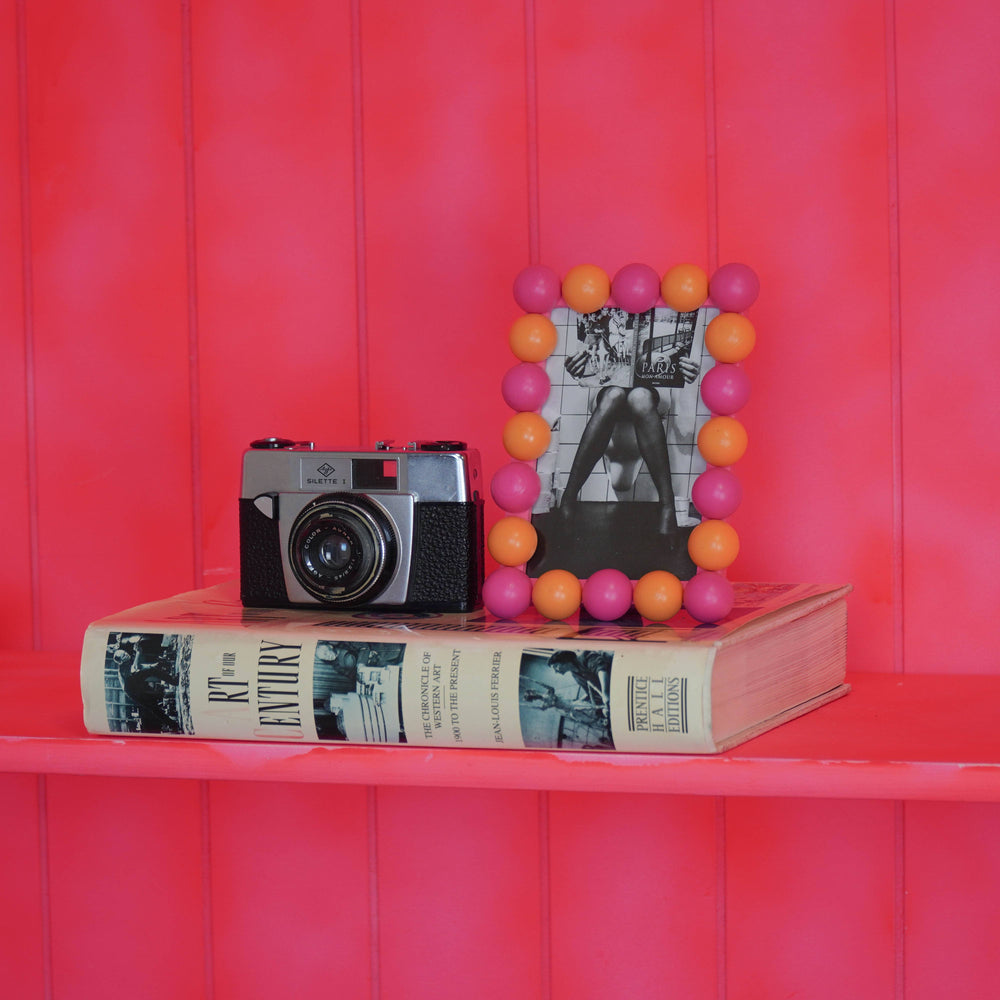 Dekorativer Perlenrahmen als farbiger Akzent auf Regal